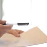 Firma de documentos legales en oficina con bolígrafo y papel.