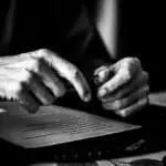 Manos firmando un documento legal en un entorno profesional.