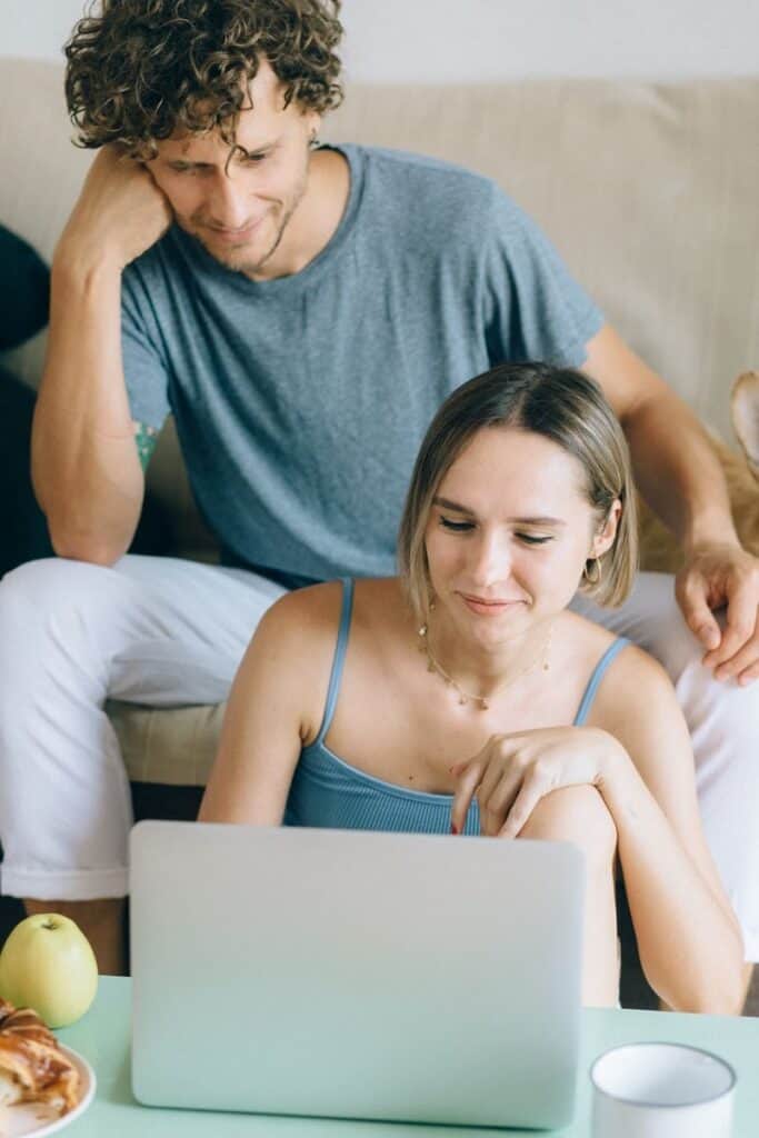 Joven pareja revisando compras en línea en casa.