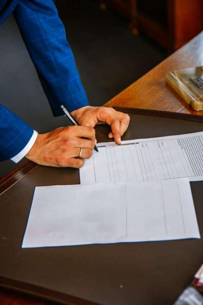 Persona firmando documento legal en oficina para reclamar tarjeta revolving