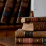 Estantería de libros antiguos en una mesa de madera.