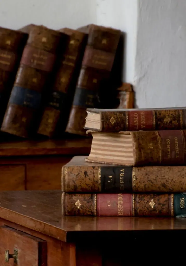 Estantería de libros antiguos en una mesa de madera.