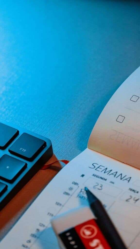 Agenda semanal y bolígrafo sobre mesa de trabajo en oficina.